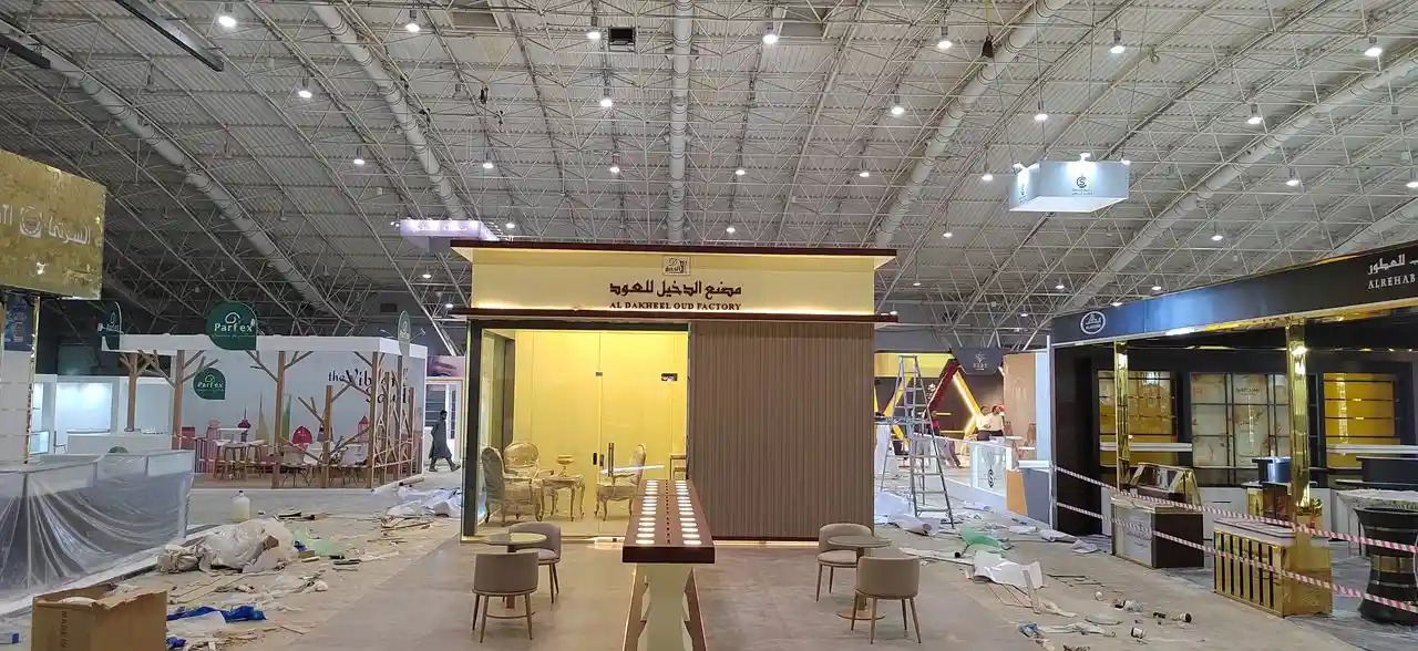 بناء بوث عود فاخر بخامات داكنة وإضاءة دافئة
